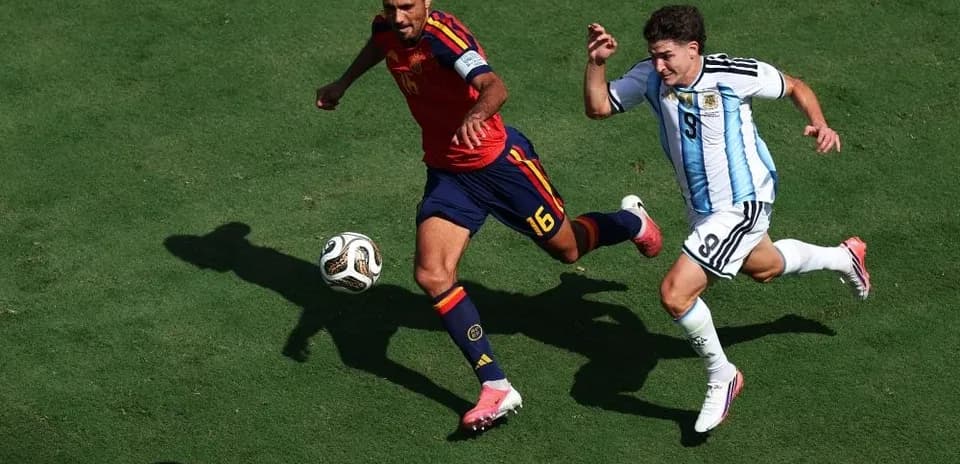 Ispaniya va Argentina futbolchilari to'pni quvlayapti