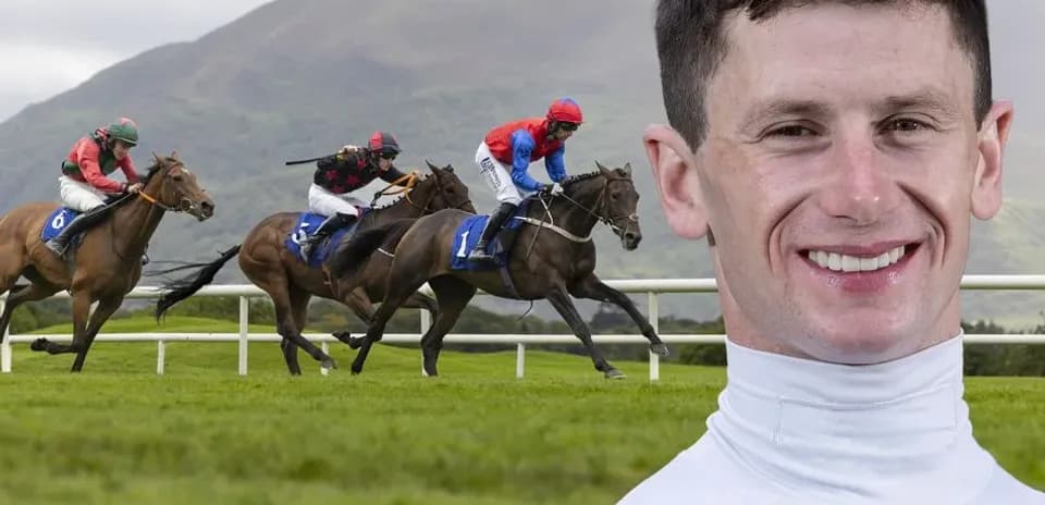 Jockeys racing horses on track with mountains behind