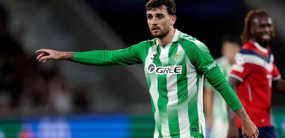 Futbolchi maydonda qo'lini ko'tarib ko'rsatmoqda