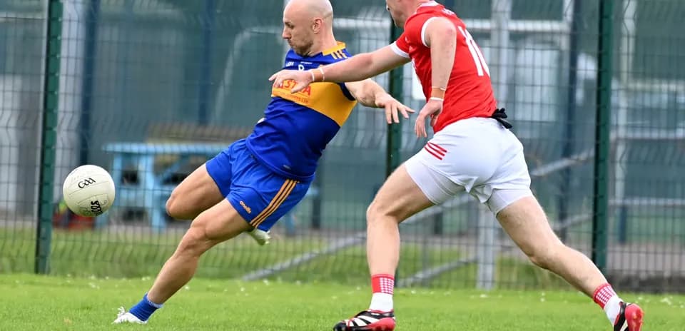 Two players competing for the ball during Gaelic football match