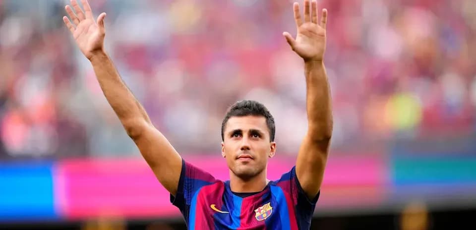 Futbolchi Barcelona formasida qo'llarini ko'tarib turibdi