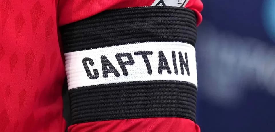 Qizil futbol formasi ustidagi kapitan tasmasi