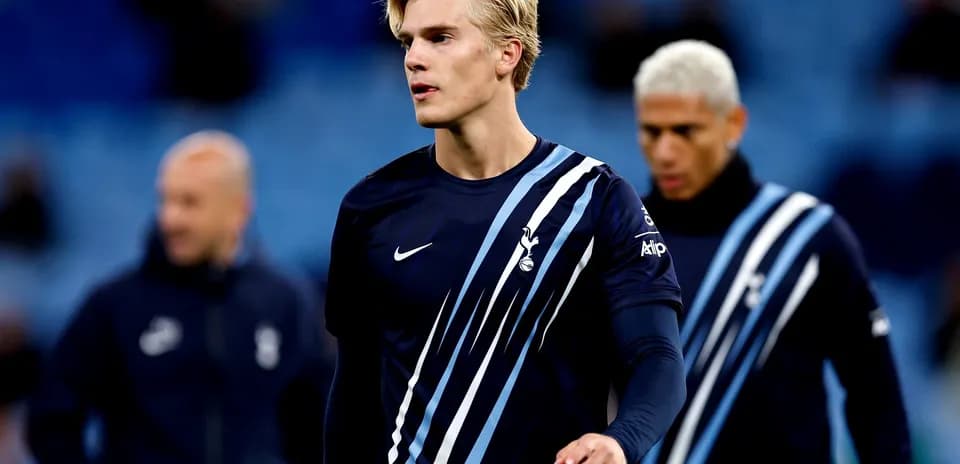 Futbolchi mashg'ulotda, orqa fondda jamoa a'zolari