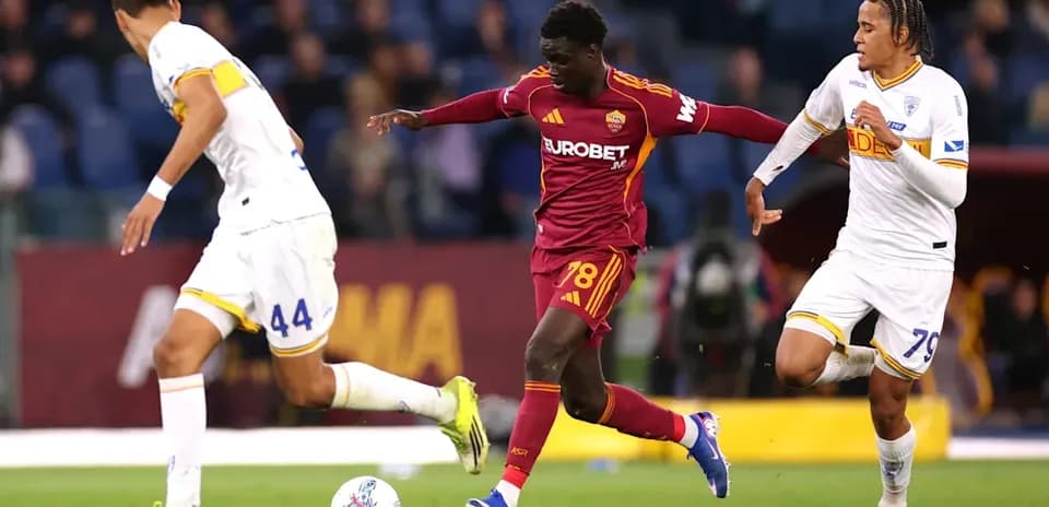 Roma player dribbling past two defenders during match