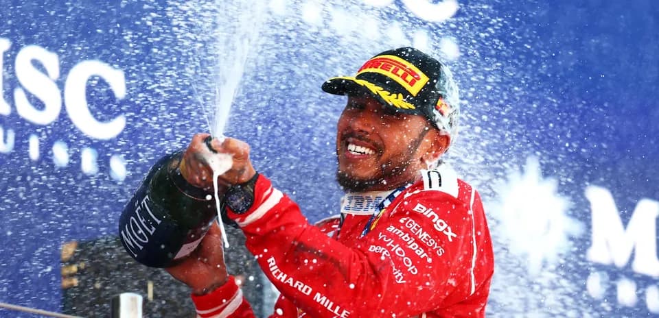 Driver celebrating with champagne on podium