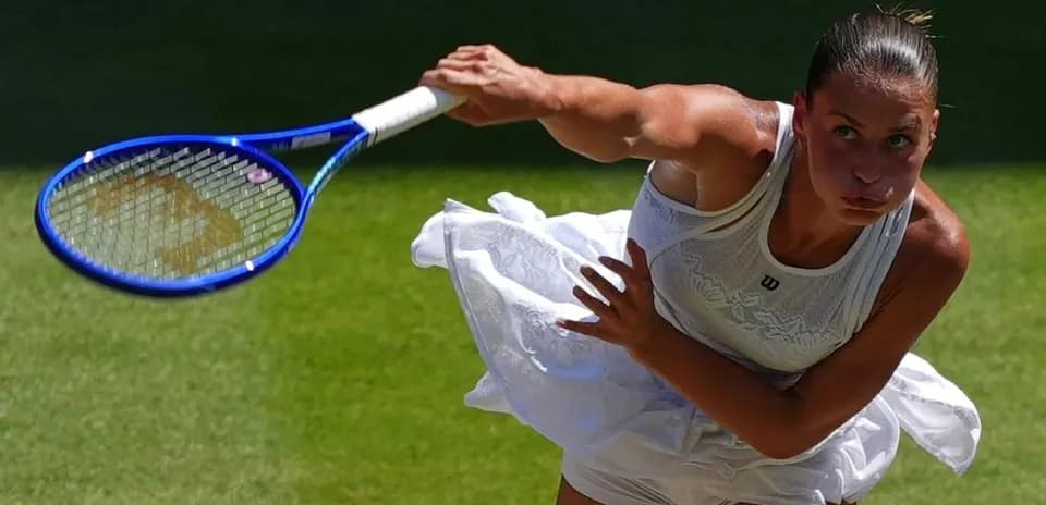 Tennis player serving on grass court