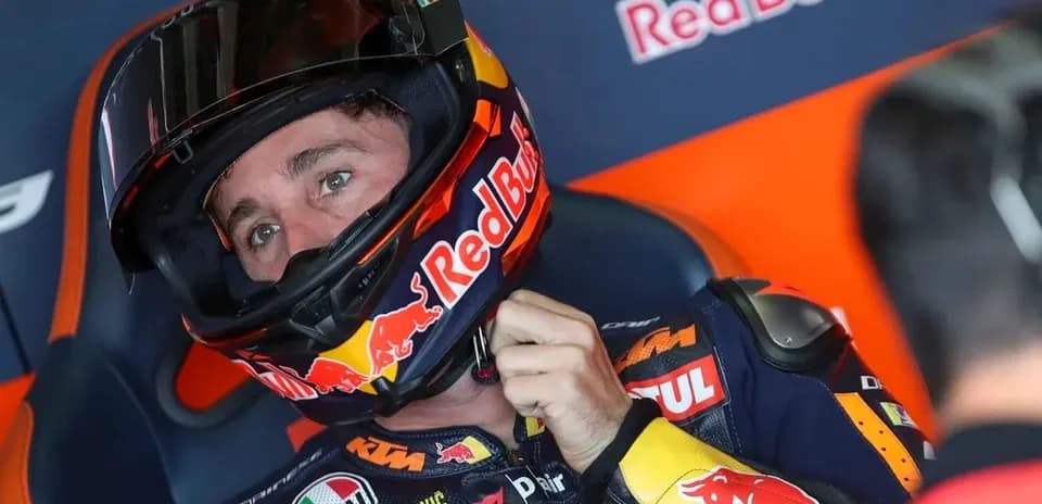 Rider adjusting helmet in Red Bull KTM garage