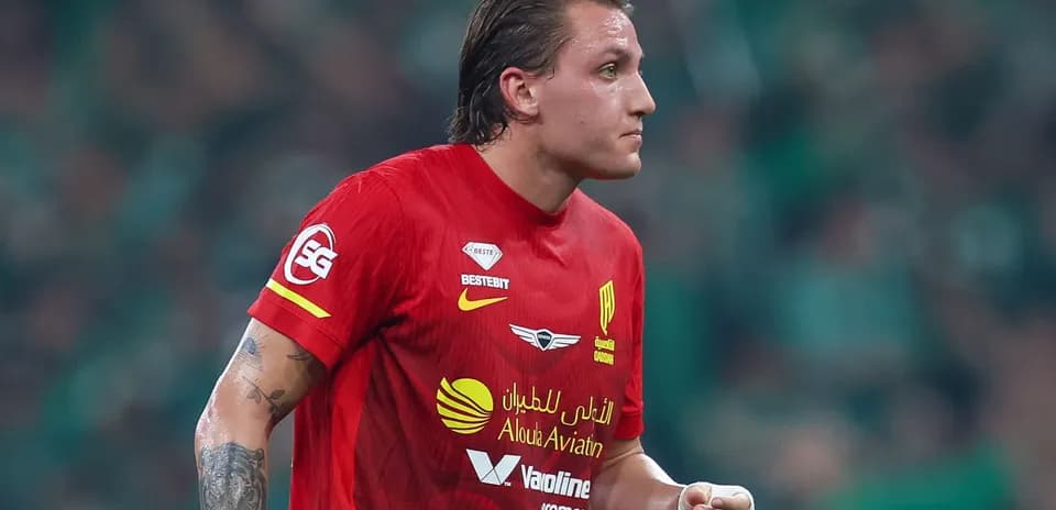 Futbolchi qizil forma kiygan, maydonda harakatda