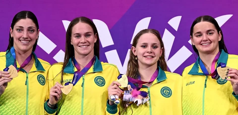 Four swimmers with gold medals on podium