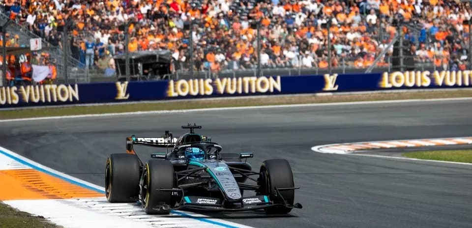 Formula 1 car racing on track with spectators in background