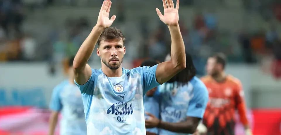 Futbolchi maydonda qo'llarini ko'tarib turibdi
