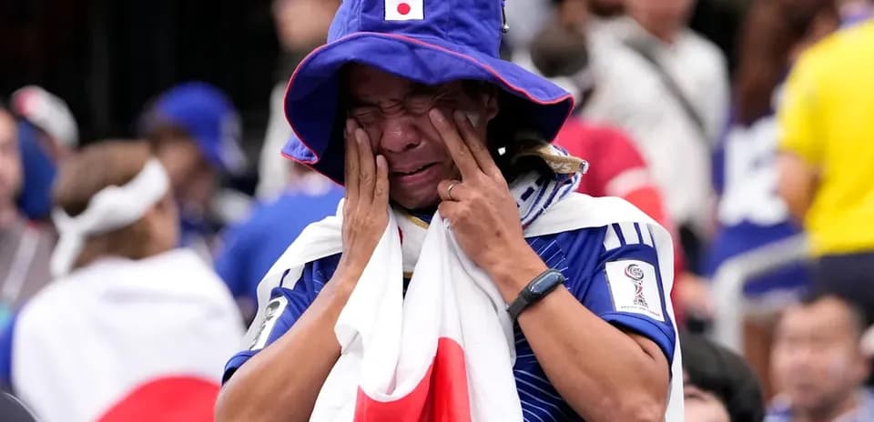 Japan fan wearing national flag and hat in crowd