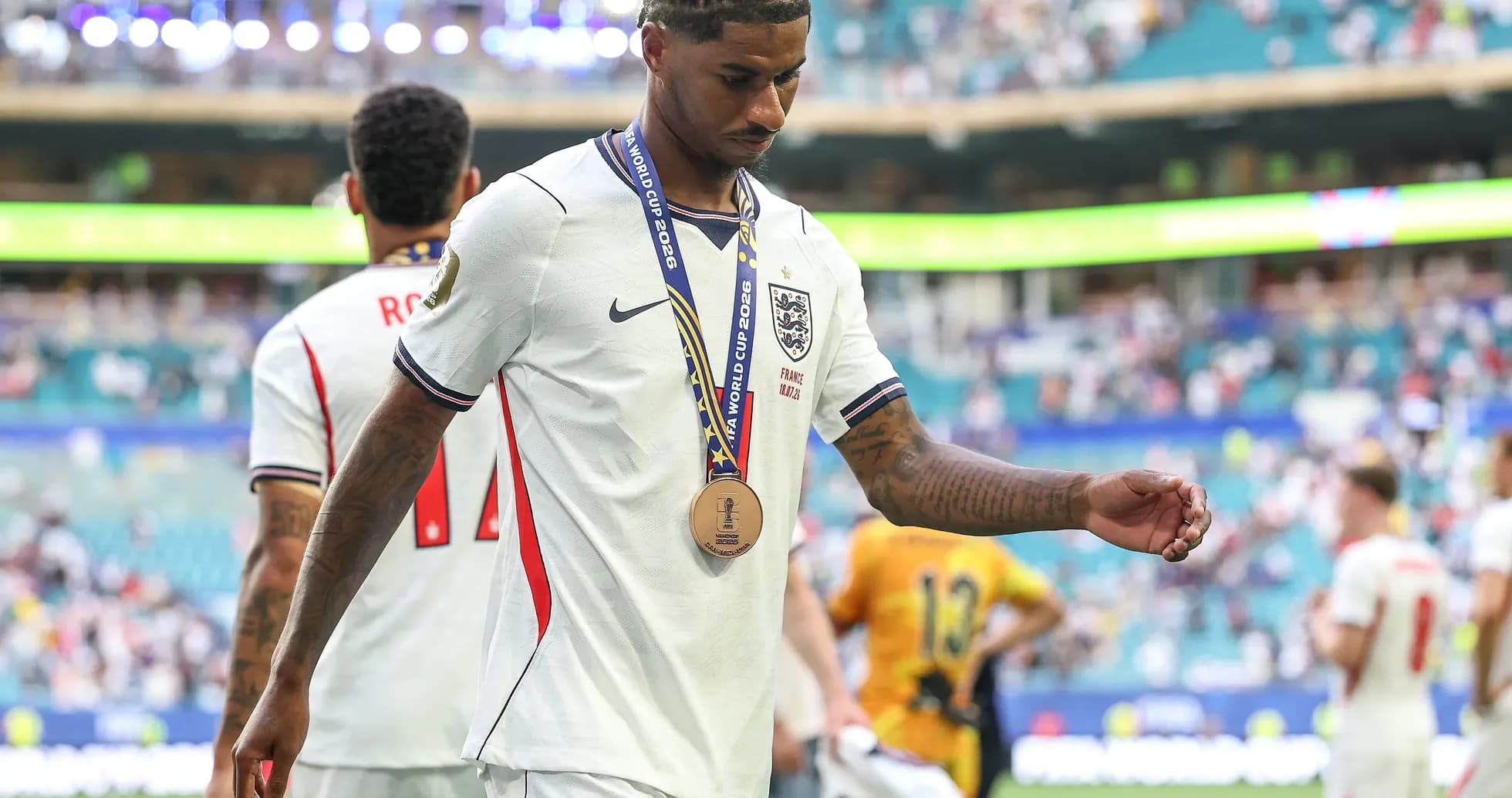 Futbolchi medali bilan maydondan chiqmoqda