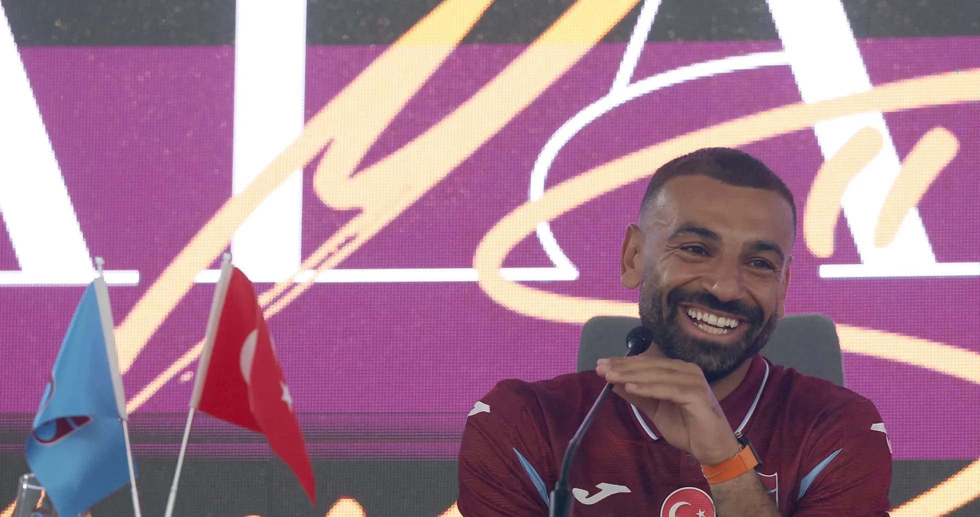 Futbolchi matbuot anjumanida kulayotgan holatda