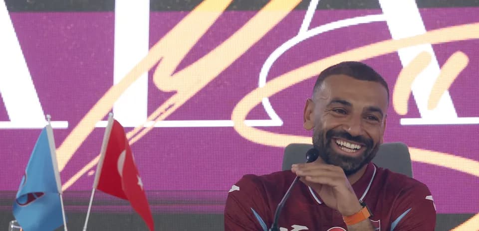 Futbolchi matbuot anjumanida kulayotgan holatda
