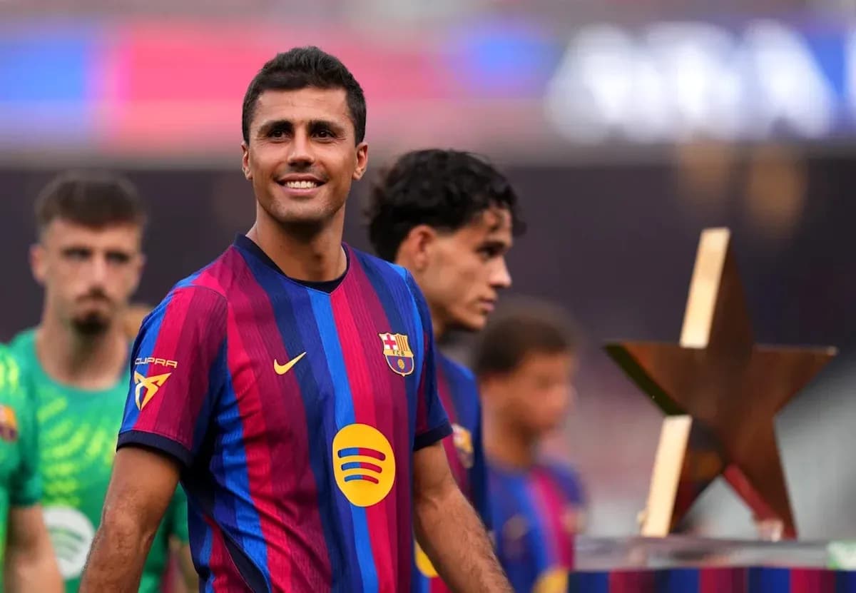 Barcelona player smiling with teammates and trophy
