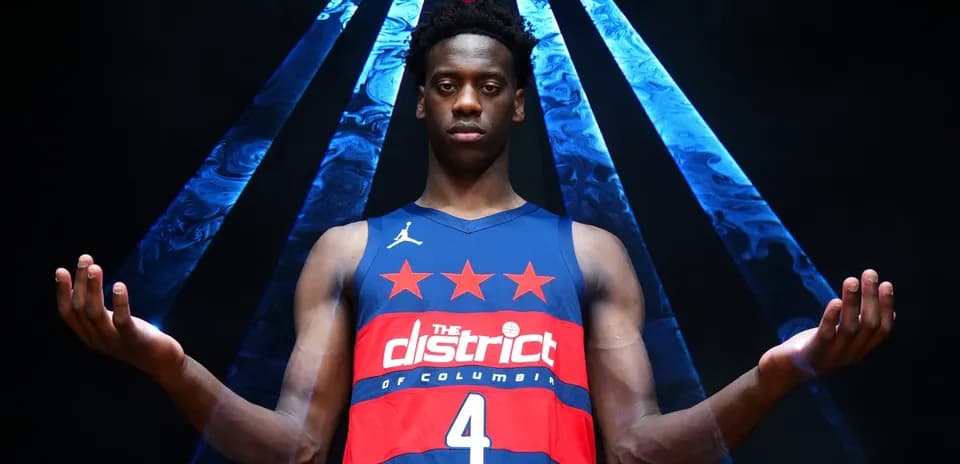 Basketball player posing in team jersey with arms raised