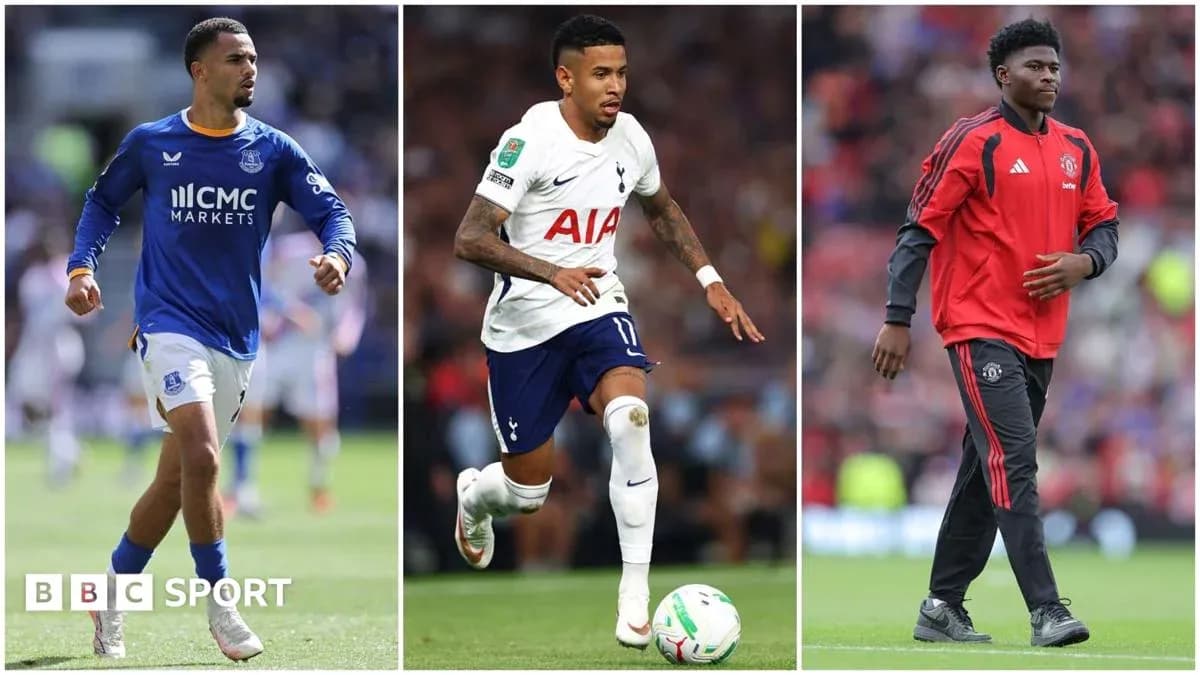 Three football players in team kits on the pitch