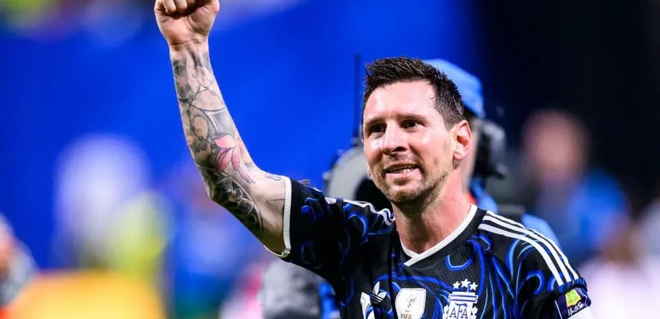 Futbolchi g'alabasi bilan qo'lini ko'tarib turibdi