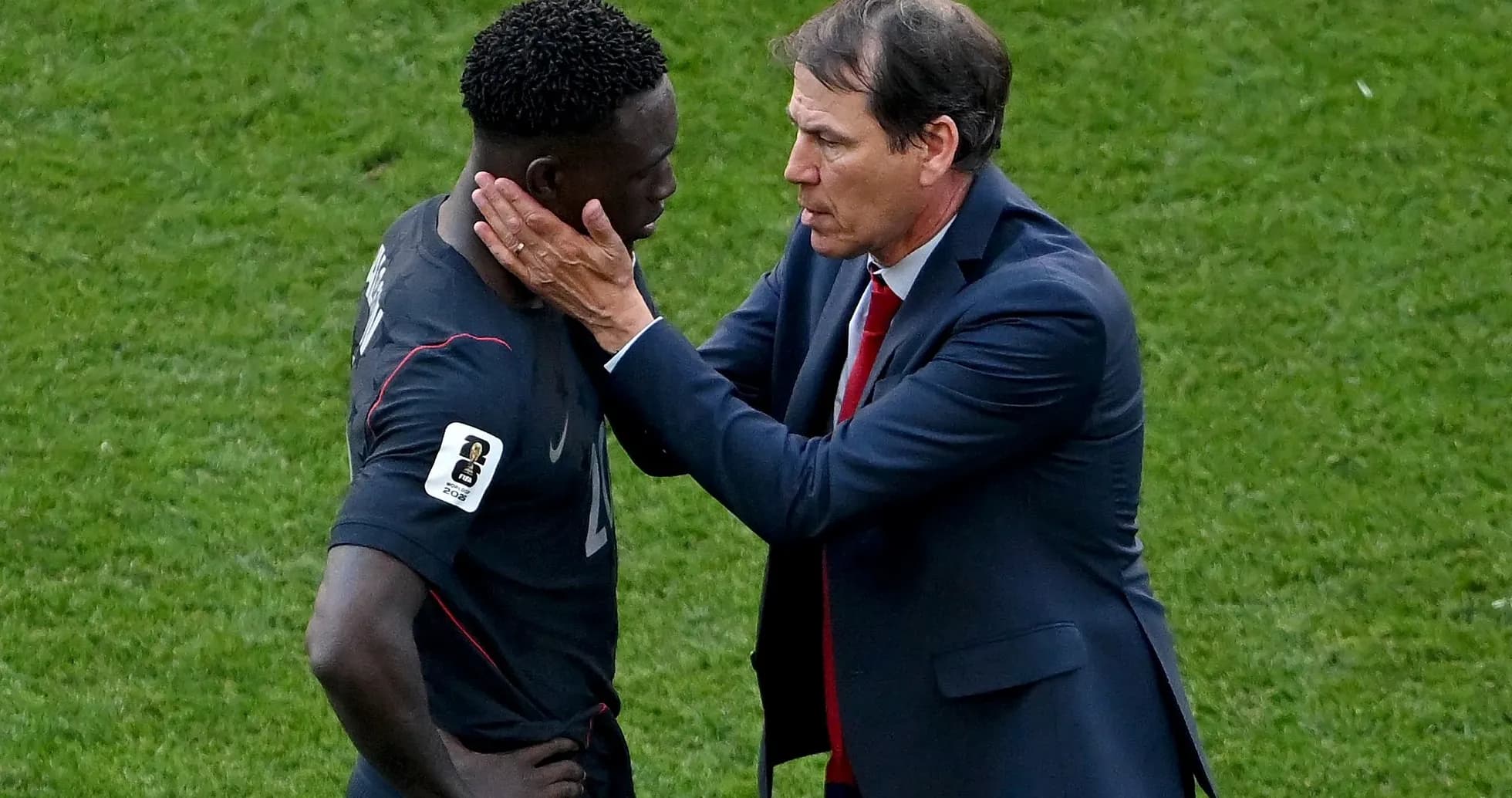 Coach discussing strategy with player on field