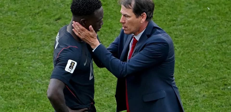 Coach discussing strategy with player on field