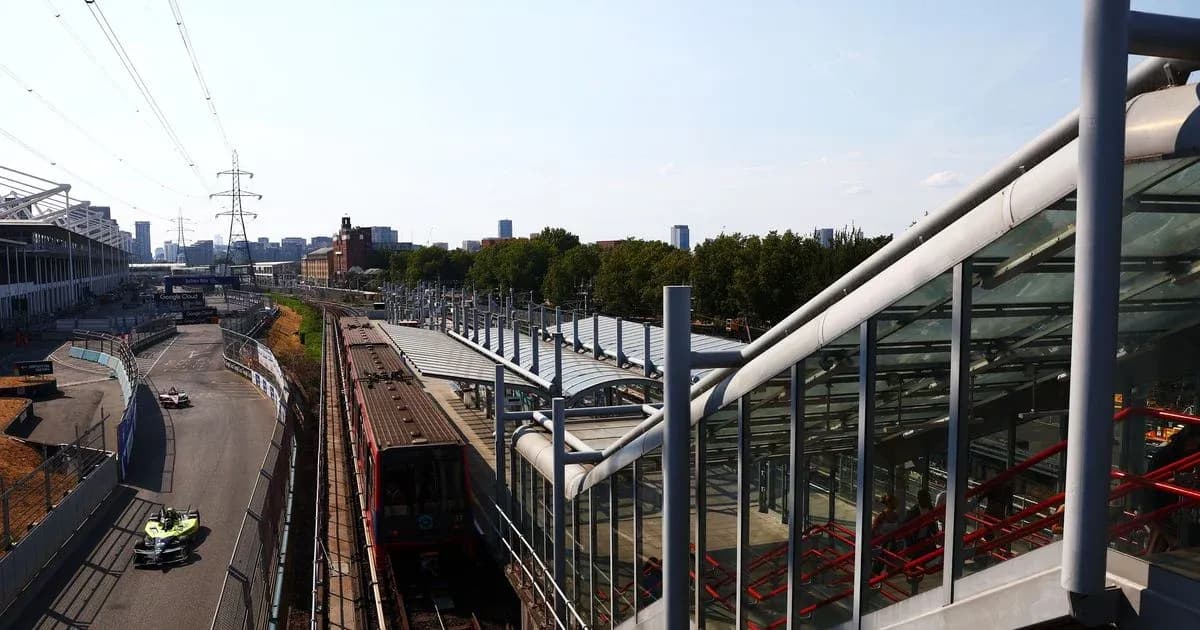 Formula E car racing near train station and city skyline