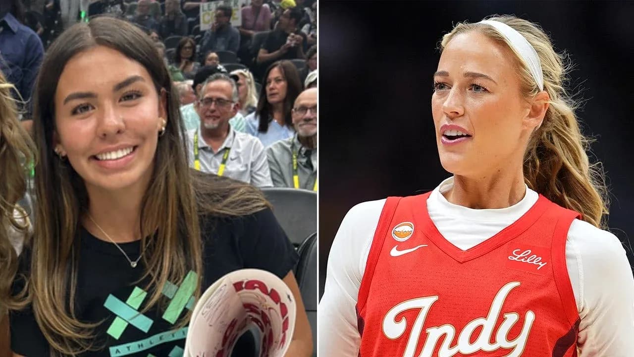 Two women, one in a basketball uniform, smiling