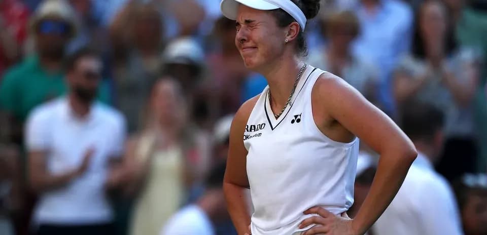 Tennis player reacting during a match with crowd behind