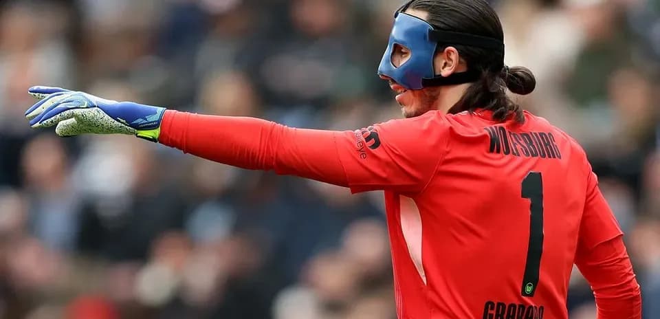 Goalkeeper in red jersey gesturing during match