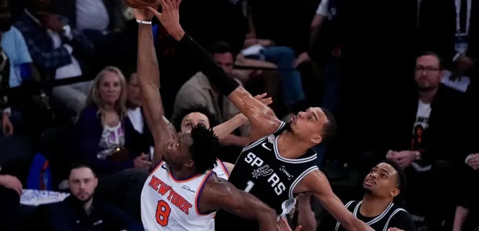 New York player attempting a shot against San Antonio defense