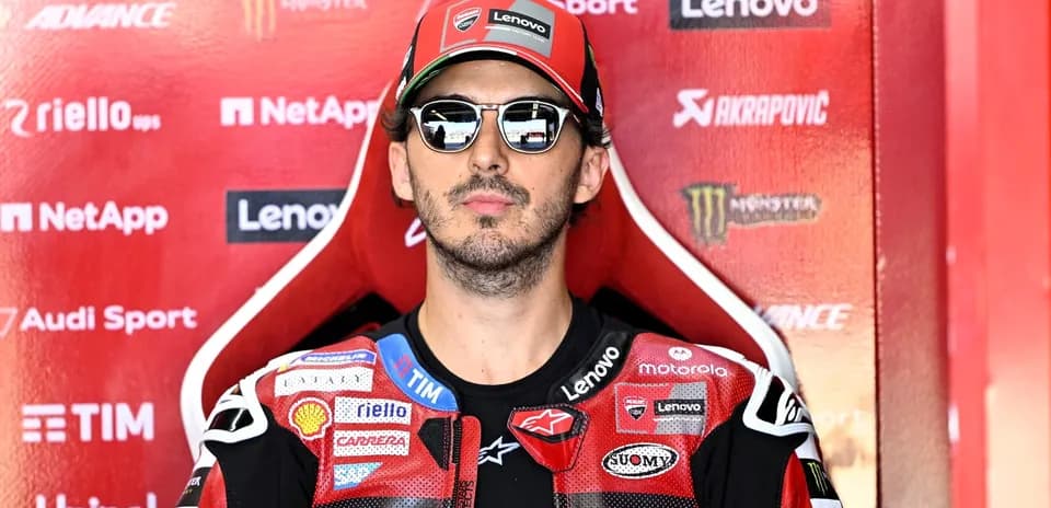 Rider in sunglasses sitting in team pit area