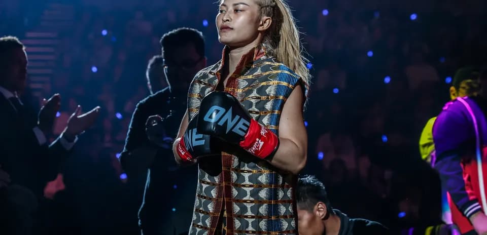 Female fighter entering arena with gloves on