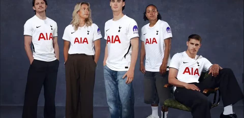 Five people wearing Tottenham jerseys posing together
