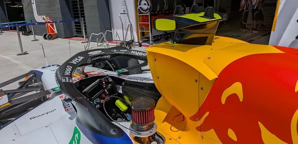 Formula 1 car in garage with team equipment