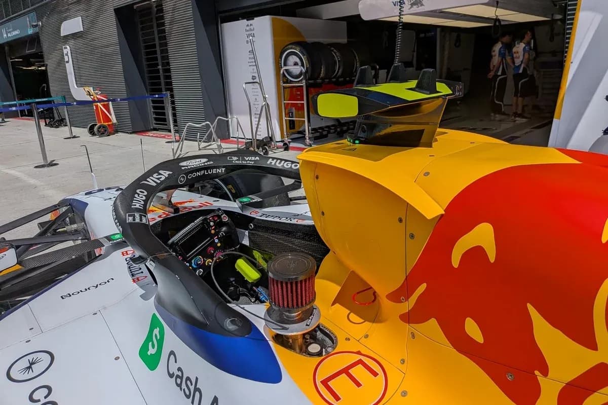 Formula 1 car in garage with team equipment