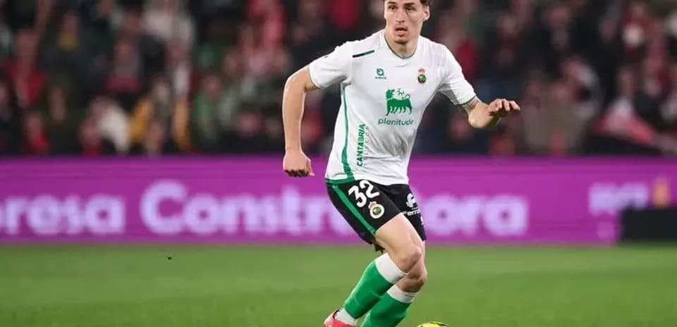 Futbolchi to'p bilan yugurib bormoqda
