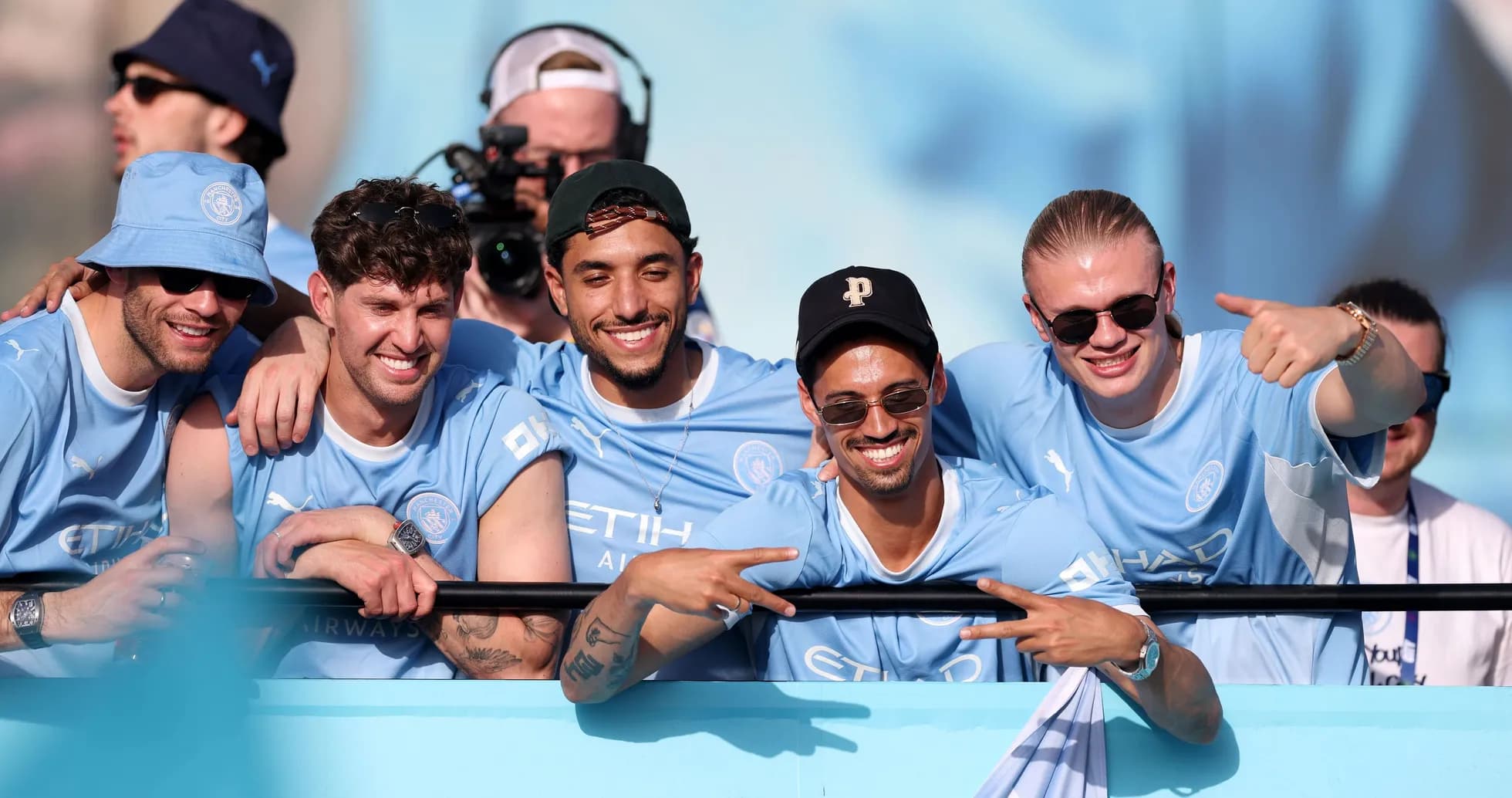 Five fans celebrating in Manchester City jerseys