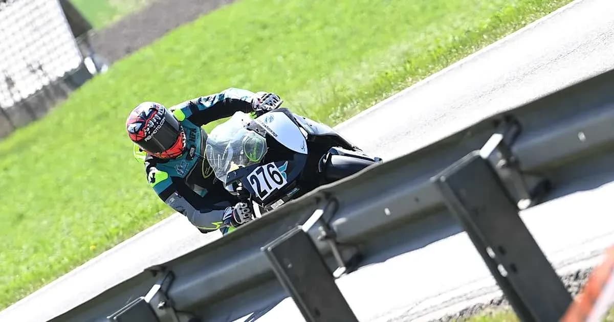 Rider leaning into a curve on motorcycle track Rider leaning into a curve on motorcycle track