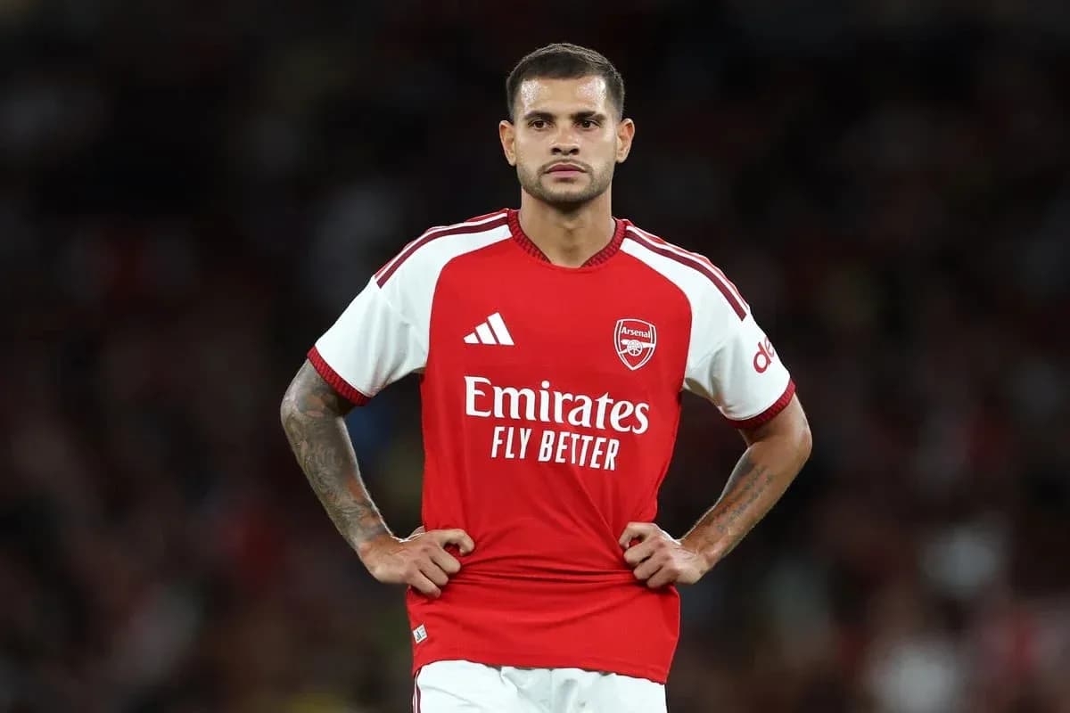 Futbolchi Arsenal futbolka kiygan, maydonda turibdi Futbolchi Arsenal futbolka kiygan, maydonda turibdi