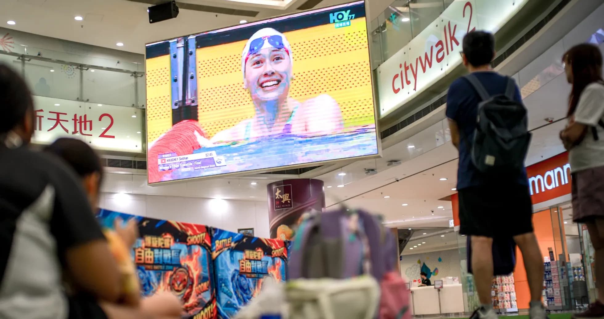 People watching swimming competition on large screen People watching swimming competition on large screen