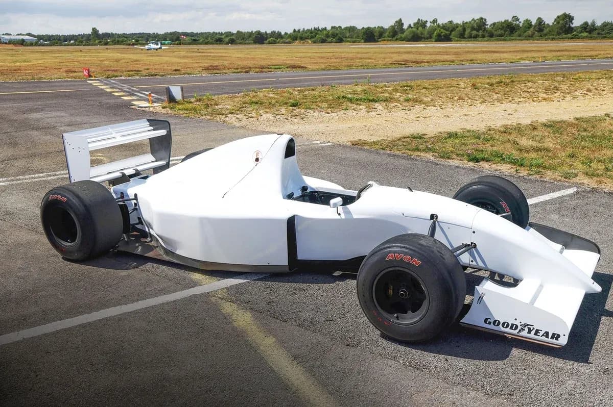 White race car parked on tarmac at airfield White race car parked on tarmac at airfield