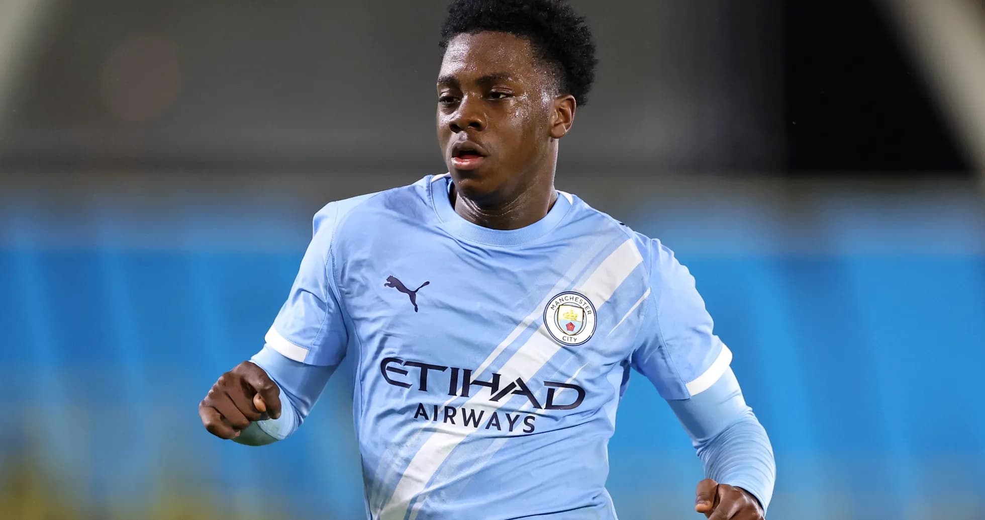 Futbolchi Manchester City formasida maydonda harakatlanmoqda Futbolchi Manchester City formasida maydonda harakatlanmoqda
