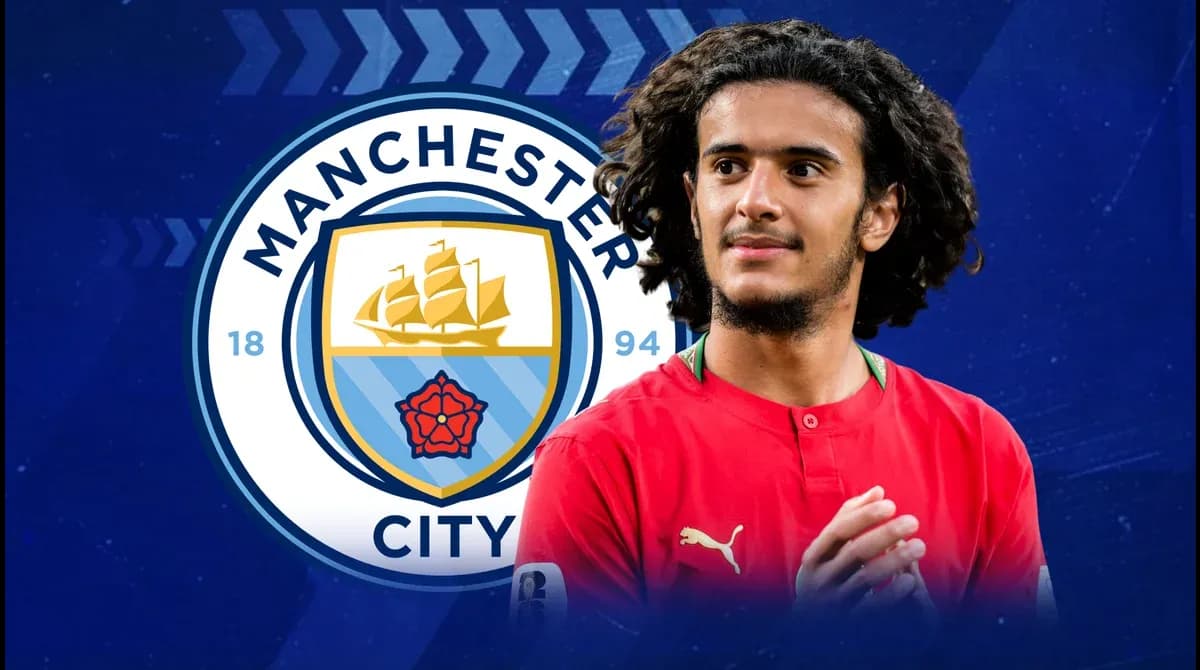 Futbolchi Manchester City logosi oldida turibdi Futbolchi Manchester City logosi oldida turibdi