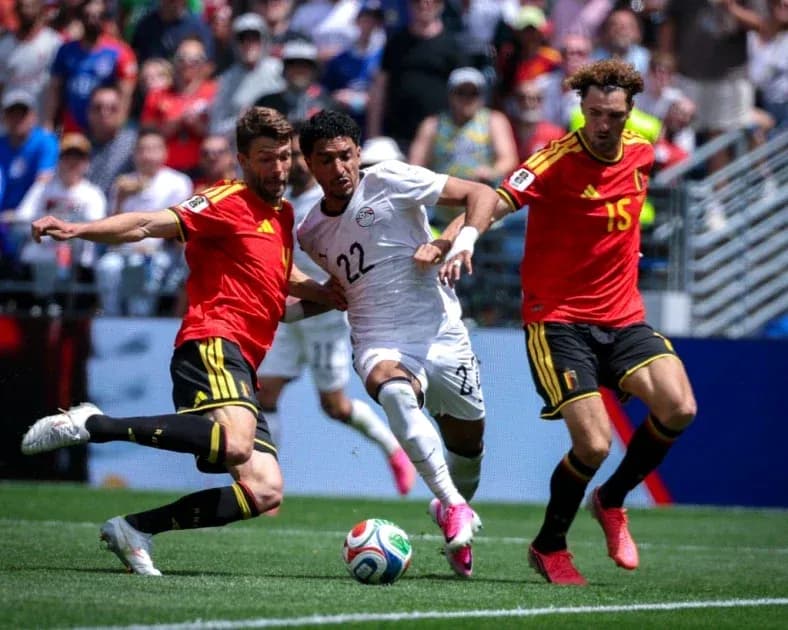 Egyptian player tackled by two Belgian defenders Egyptian player tackled by two Belgian defenders