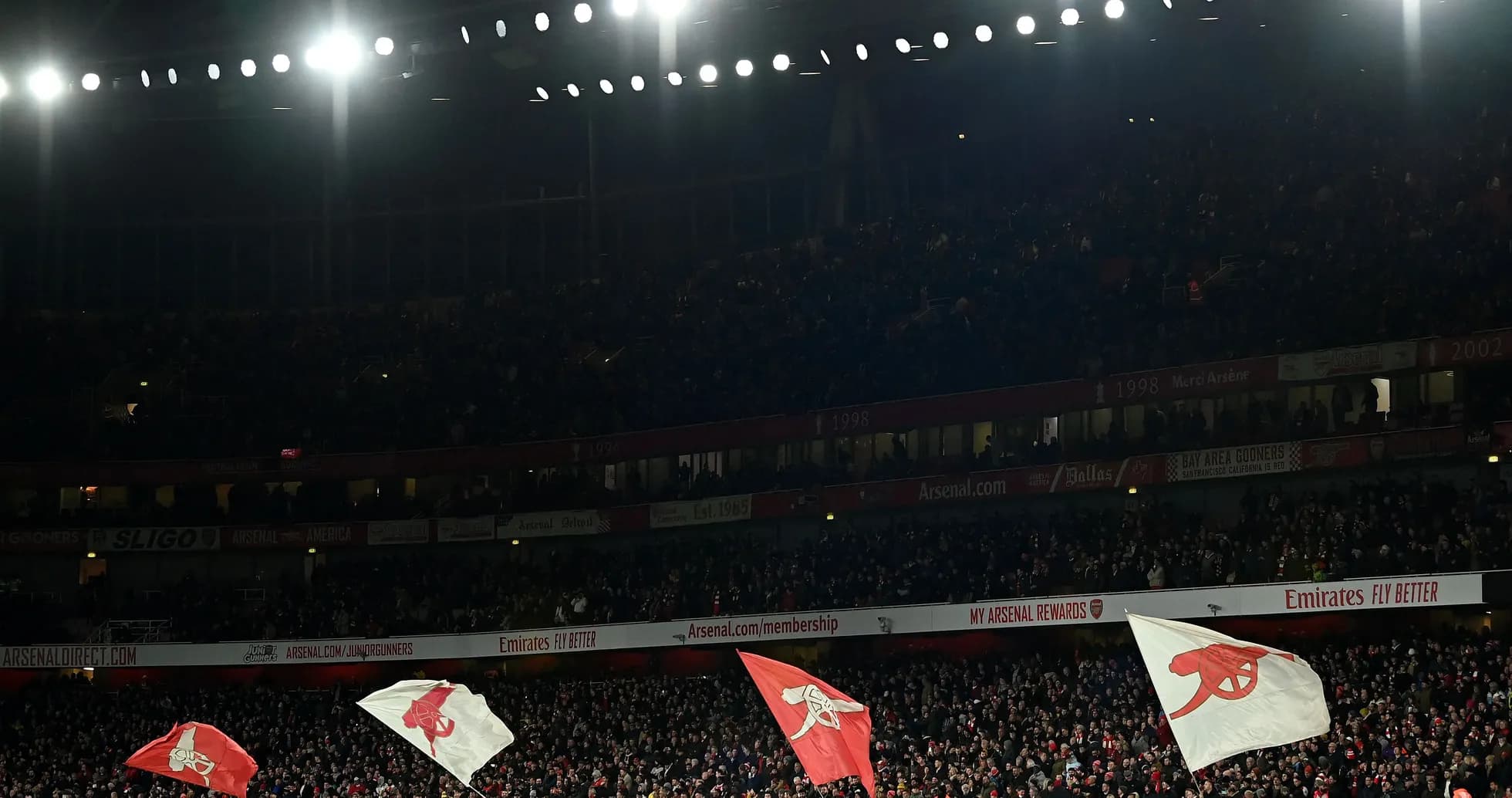 Arsenal fans waving flags in the stadium Arsenal fans waving flags in the stadium