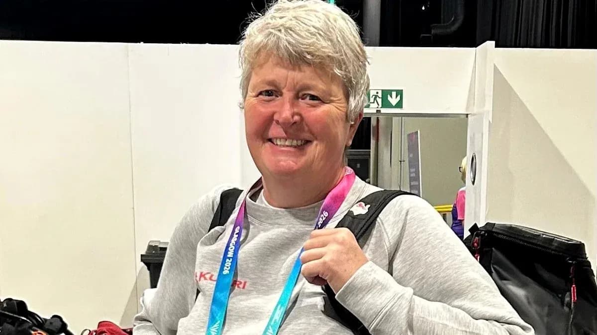 Woman smiling with sports accreditation lanyard around neck Woman smiling with sports accreditation lanyard around neck