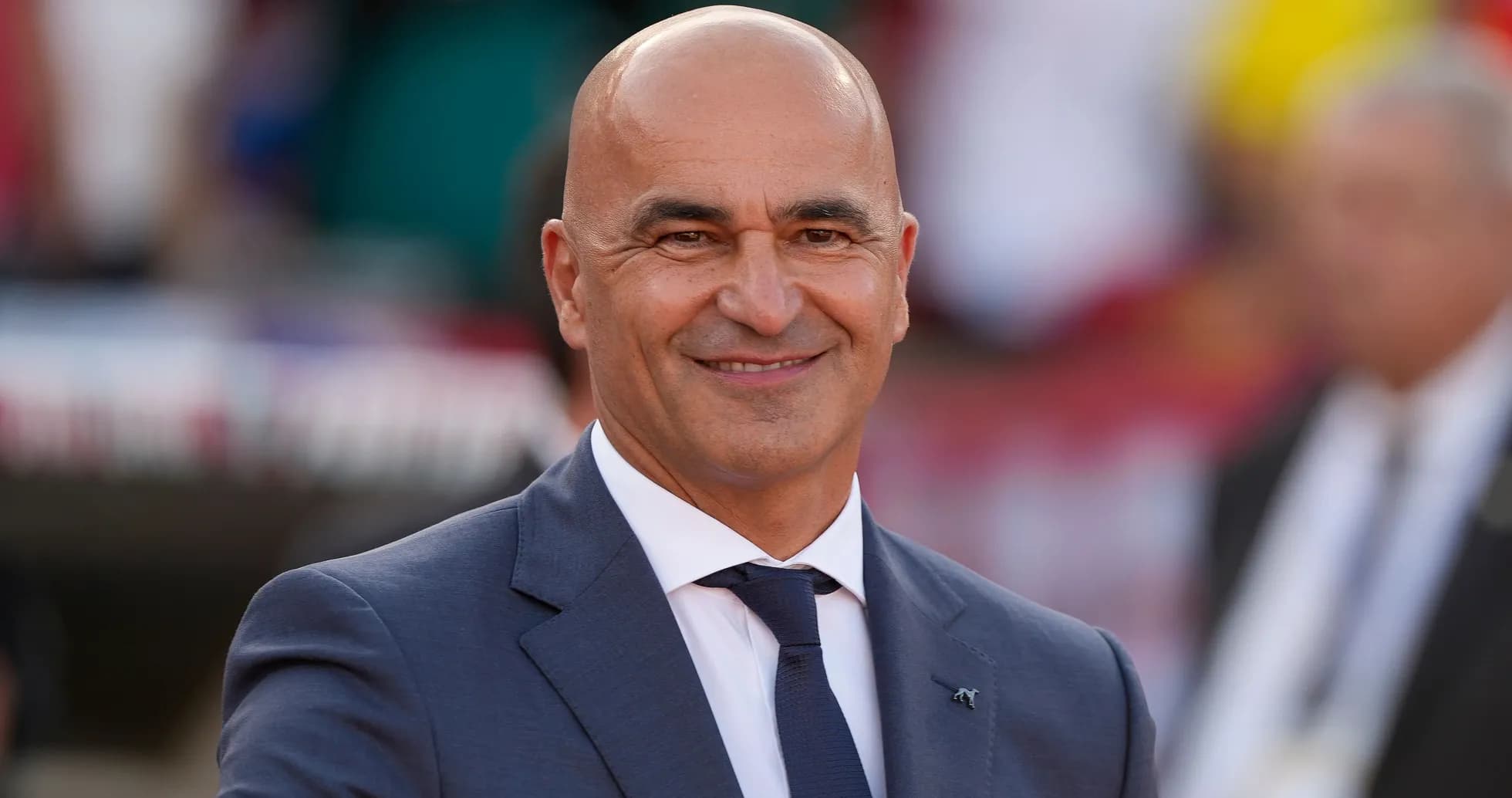 Kiyimdagi murabbiy stadionda tabassum qilmoqda Kiyimdagi murabbiy stadionda tabassum qilmoqda