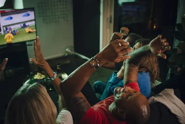 Group celebrating while watching football on TV Group celebrating while watching football on TV