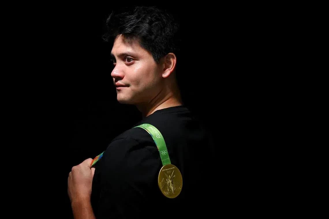 Athlete displaying Olympic gold medal on shoulder Athlete displaying Olympic gold medal on shoulder