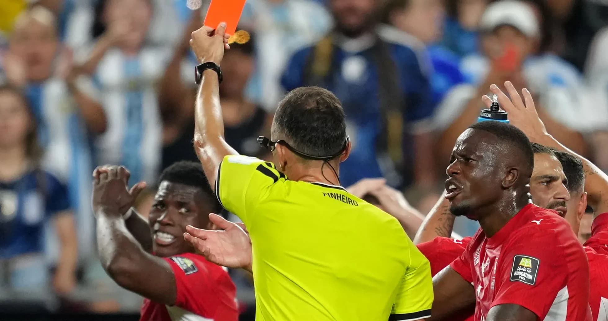 Referee showing red card during heated match situation Referee showing red card during heated match situation